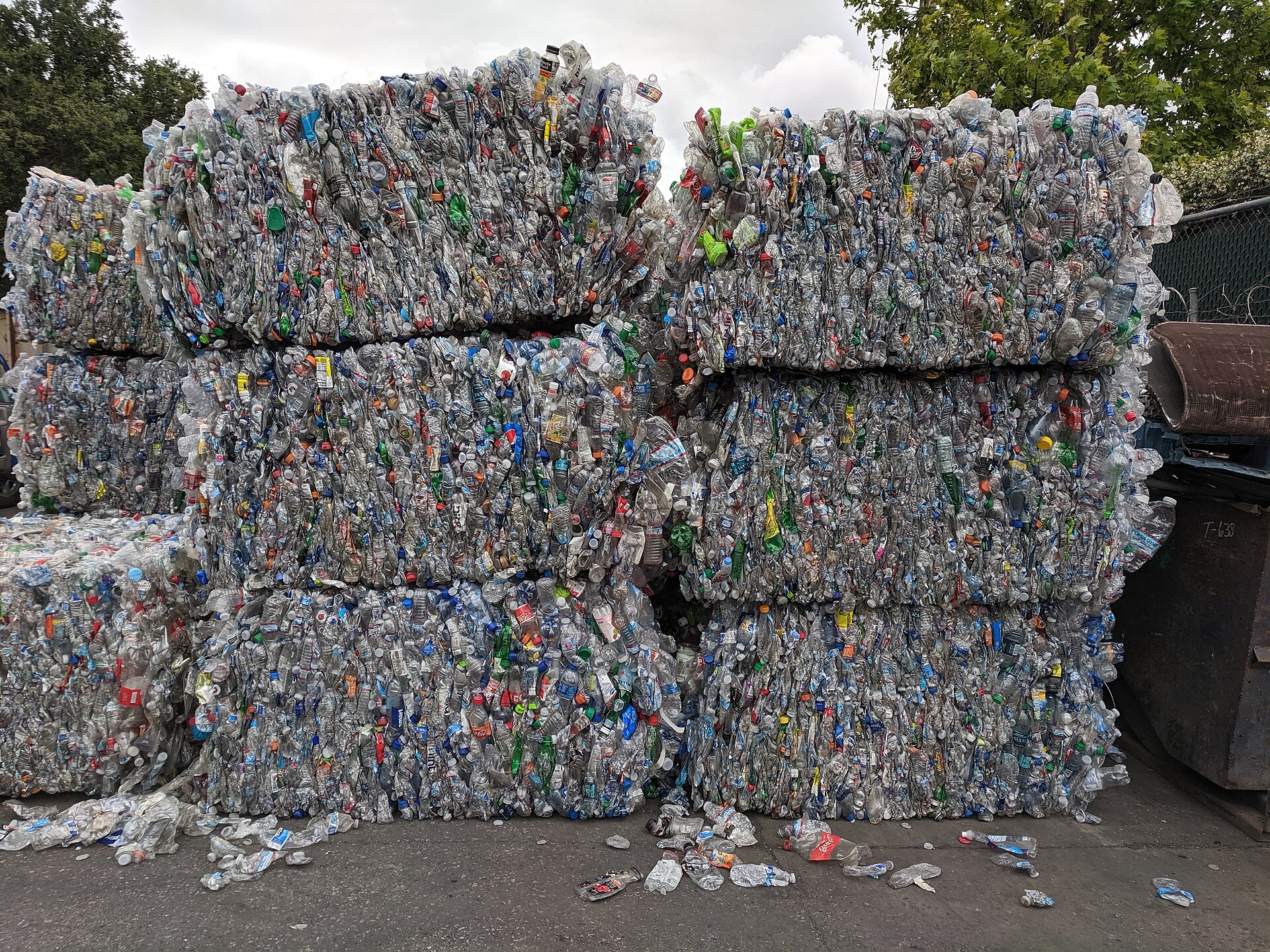 Stacked bales of crushed PET bottles at a recycling facility
